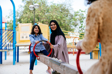 Wall Mural - Mom and daughters spending time together at the park, in Dubai