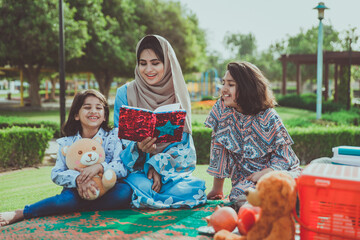 Wall Mural - Mom and daughters spending time together at the park, in Dubai