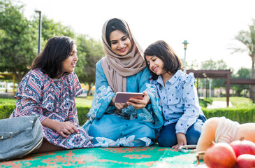 Wall Mural - Mom and daughters spending time together at the park, in Dubai