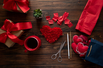 Valentine gift making, DIY. Peper and felt hearts, tea cup and gift box on wooden background. Valentines, mothers day and birthday celebration concept. Copy space. Top view.