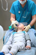 The little boy is placed under anesthesia. Preparation for dental surgery to remove multiple caries. Treatment of baby teeth. The device of artificial ventilation of lungs.