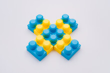 Blue Yellow Plastic Cross Figure Made Of Lego Blocks