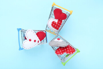 Wall Mural - Fabric hearts with shopping carts on blue background