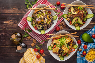 3 kinds of salad with quinoa, halloumi and steak on wooden table.