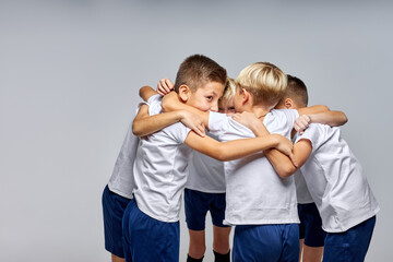 Wall Mural - boys soccer team hugging, preparing for competitions, sharing advice each other. gathered to play football, soccer. isolated