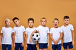 © Roman - kids soccer players with soccer ball posing while one of boys stand screaming at camera, joyful. studio portrait