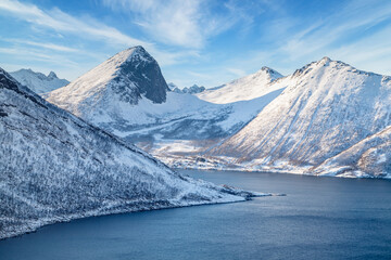 Wall Mural - Winter landscape in Lofoten islands, Norway. Coastline of the fjord and snow-covered mountains.