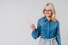 Smiling Successful Caucasian Businesswoman Pointing At Copy Space Isolated Over Grey Background