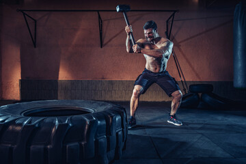 Sports training for endurance, man hits hammer. Concept workout.