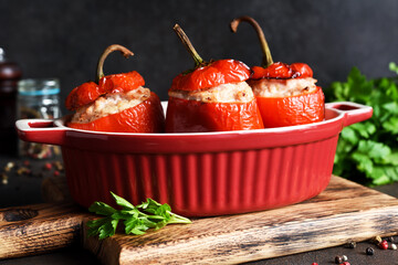 Wall Mural - Stuffed peppers baked with meat and rice on a dark concrete background