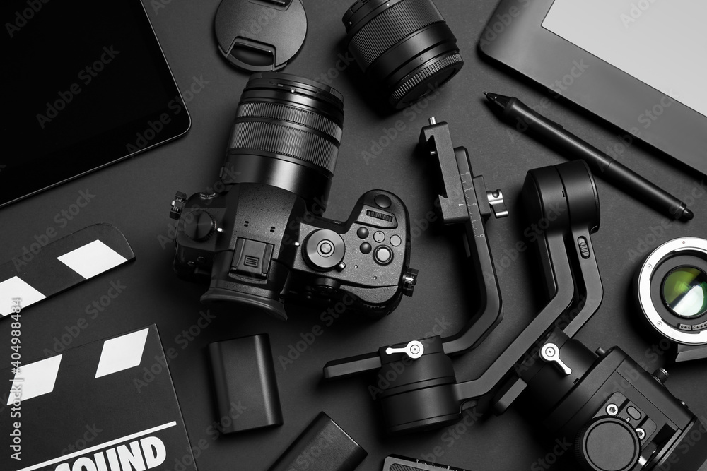 Flat lay composition with camera and video production equipment on black background - obrazy, fototapety, plakaty 