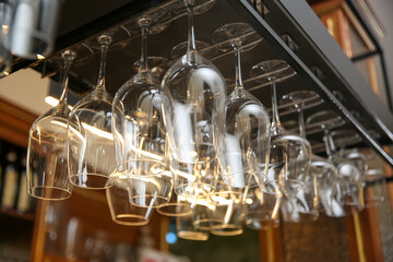 Many clean glasses on metal rack in restaurant