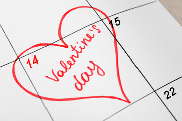 Calendar with marked Valentine's Day on table, closeup