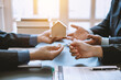 © amnaj - Signing a business contract. A group of business people meeting and signing an investment, buying and selling home and real estate agreement.