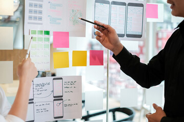 Group of designers draw a ux website to develop a mobile application at meeting.