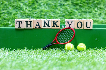 Wall Mural - Tennis ball and racket with thank you word on green grass background