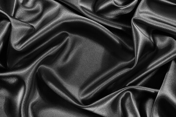 Black silk satin background. Shiny fabric with wavy folds. Beautiful fabric background with space for your design.