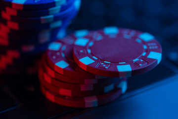 Macro shot view of poker chips on laptop keyboard. Concept of online gaming.