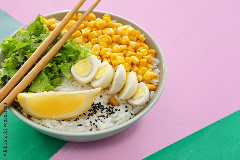 Bowl with tasty rice, eggs and vegetables on color background