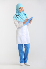 Canvas Print - Portrait of female Muslim doctor on light background