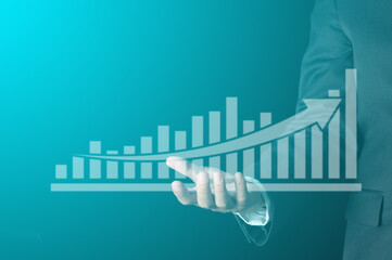 business success concept. businessman with virtual bar chart and arrow on hand show profit and revenue growth of company with copy space  