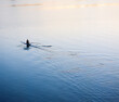 © SuperStock - Man rowing single scull rowing boat in calm water and early morning light