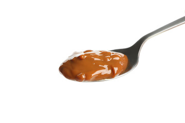 Spoon with caramel condensed milk isolated on white background