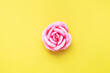 © Elenglush - Handmade soap in the shape of a rose, pink rose flower on a yellow background. Top view, minimalist, copy space.