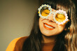 Happy, optimistic and smiling woman with flower sunglasses expresses joie de vivre and positive attitude towards life.