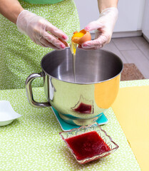 Wall Mural - The separation of the yolk from the white over the metal bowl for whipping. The process of making dessert.