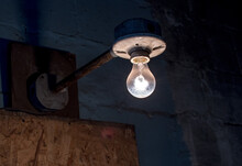 Bare Light Bulb In An Old Room Hangs From An Antique Porcelain Fixture