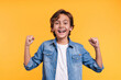 © InsideCreativeHouse - Excited young boy is happy like a winner in casual clothes isolated over yellow background