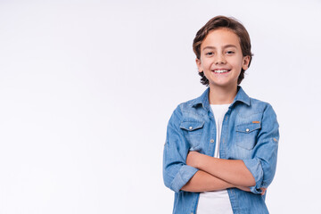 Happy young caucasian boy in casual outfit with arms crossed isolated over white background