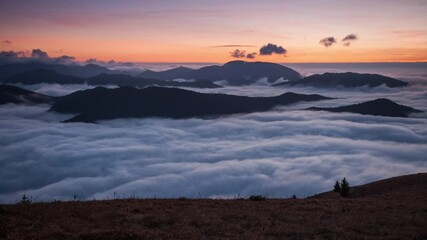 Wall Mural - time lapse - sunset hidden behind clouds and fog over hills, bright yellow sun on colorful cloudscap