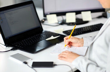 business, technology and people concept - businesswoman with notebook and laptop computer working at office