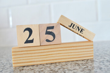 june 25, cover design with number cube on a white background and granite table.