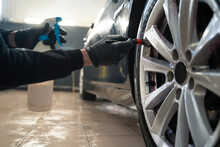 Detailing Center Worker Cleans Car Wheels With Brush. Vehicle Wheel Rim Cleaning Process