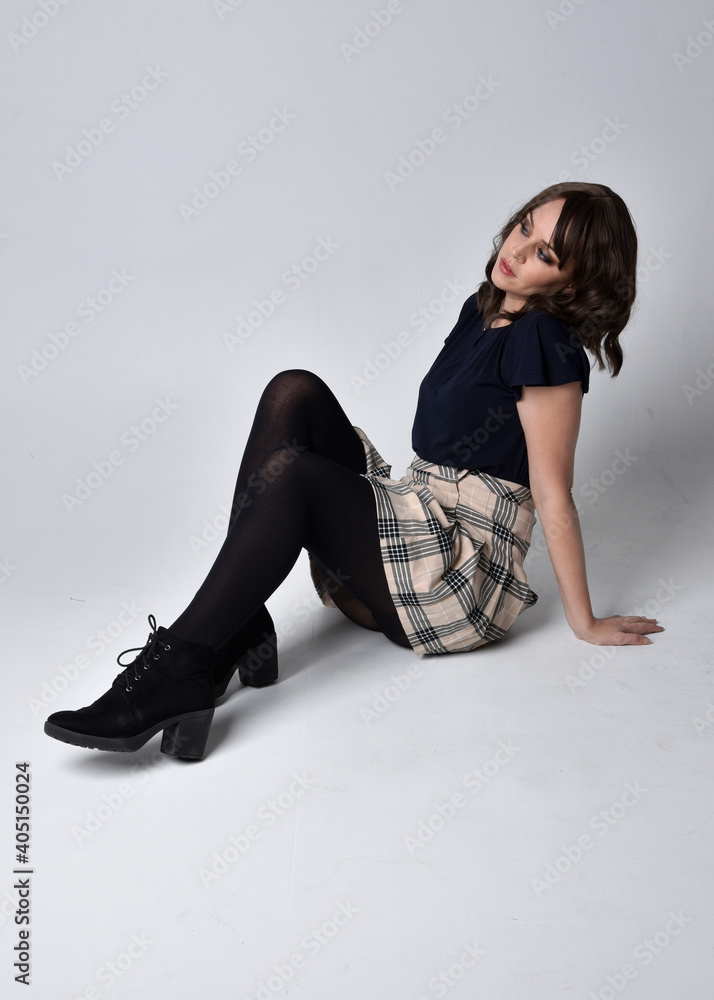 Full length portrait of pretty brunette woman wearing tartan skirt and ...