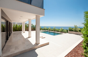 The modern facade of a luxury villa with a large swimming pool. Luxury MODERN property.