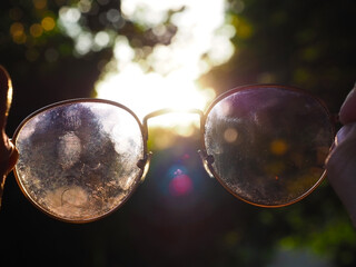 Glasses with patched blurred glasses against a background of bright light and bokeh