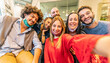© Davide Angelini - Group of friends wearing face masks taking a selfie with smart phone mobile indoor - New normal friendship concept with young people having fun together at restaurant