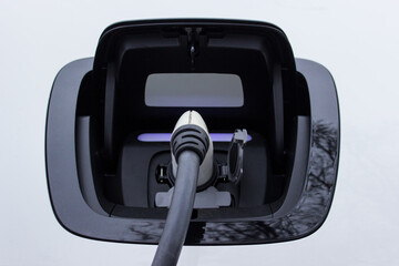 Socket of an electric car with plugged in charger.