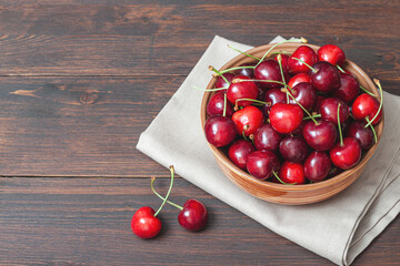 Cherry on plate bowl on wooden background.