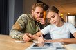 © Drobot Dean - Masculine focused military man doing homework with her daughter at home