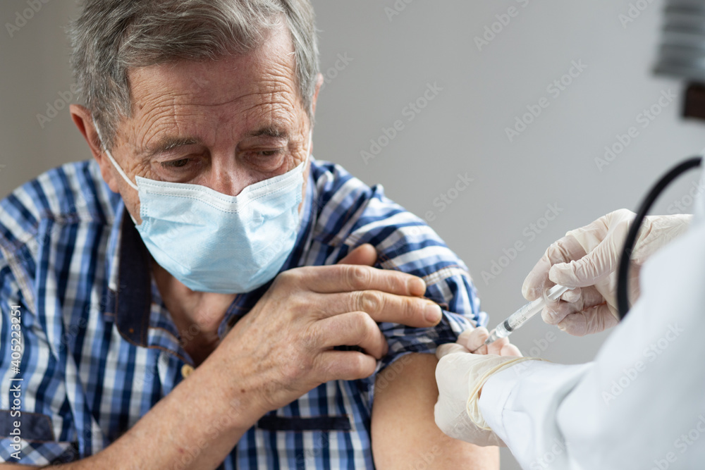 elderly man getting coronavirus vaccine - obrazy, fototapety, plakaty 