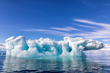 Wall Mural - blue ice iceberg, formed when a glacier calves, floating in the arctic waters of svalbard, arctic ci