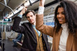 © LIGHTFIELD STUDIOS - man looking at cheerful african american woman in subway on blurred foreground