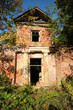 old ruined abandoned red brick building in autumn forest