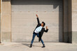 © VITTA GALLERY/Westend61 - Cheerful young man dancing against shutter on sunny day