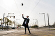 © VITTA GALLERY/Westend61 - Young man throwing his hat in air on street during sunny day